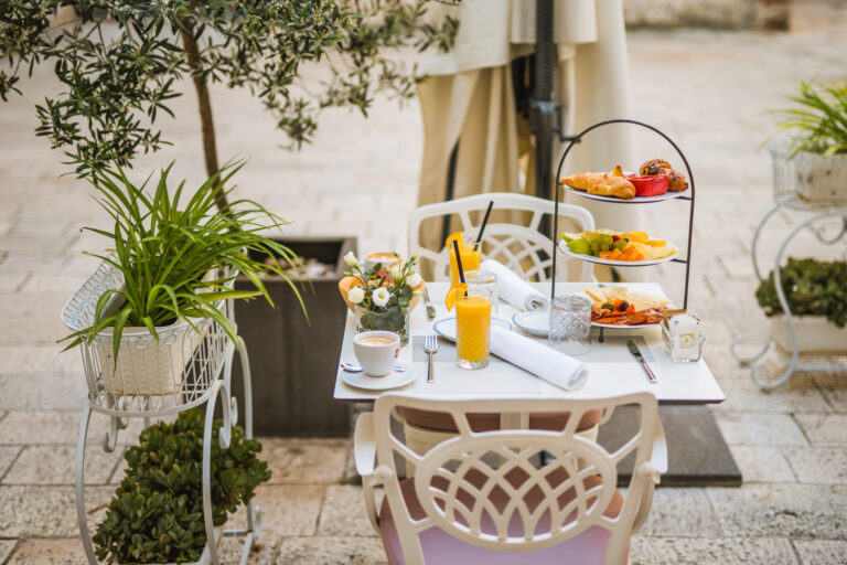 Three-tier breakfast stand with pastries, fresh fruit, cheeses and cured meats.