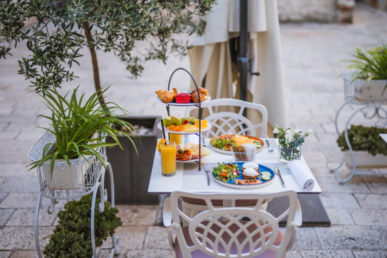Three-tier breakfast stand with pastries, fresh fruit, cheeses and cured meats.