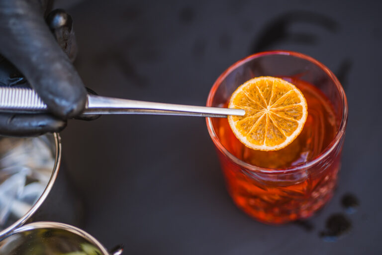 A glass of alcohol with a slice of lemon
