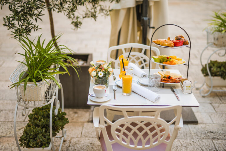 Three-tier breakfast stand with pastries, fresh fruit, cheeses and cured meats.