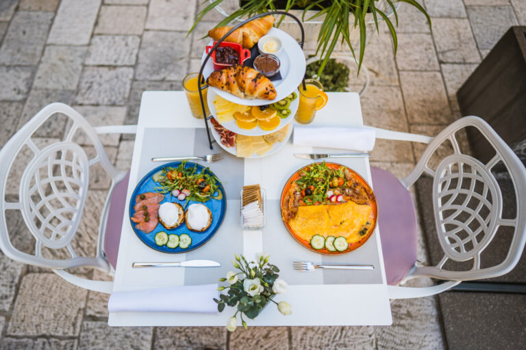 Three-tier breakfast stand with pastries, fresh fruit, cheeses and cured meats.