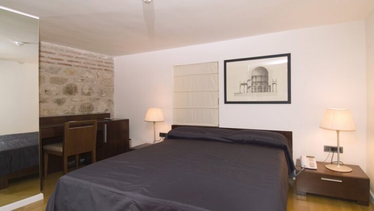 Standard room bed and ancient wall
